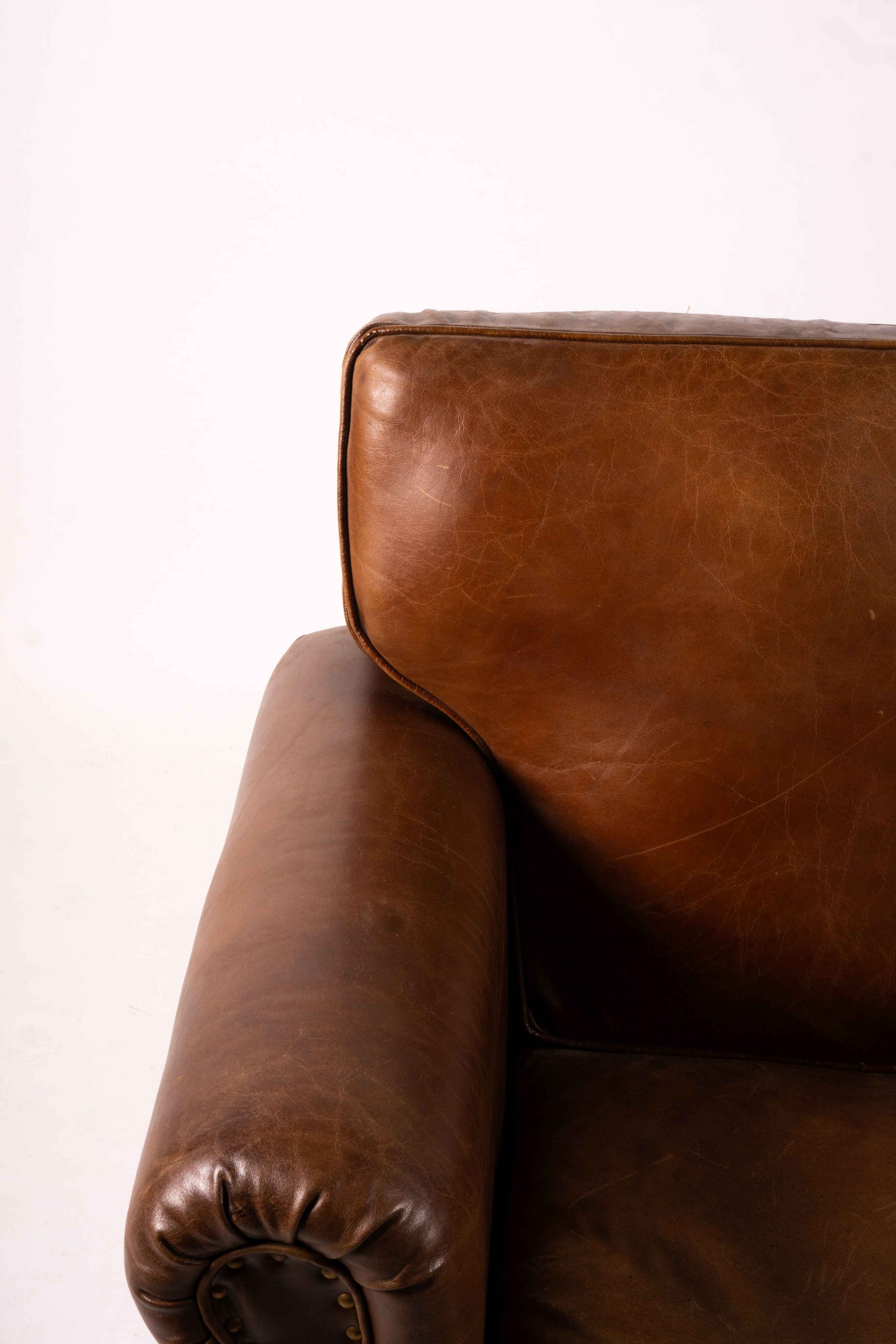 A pair of brown leather club armchairs, width 96cm, depth 80cm, height 90cm